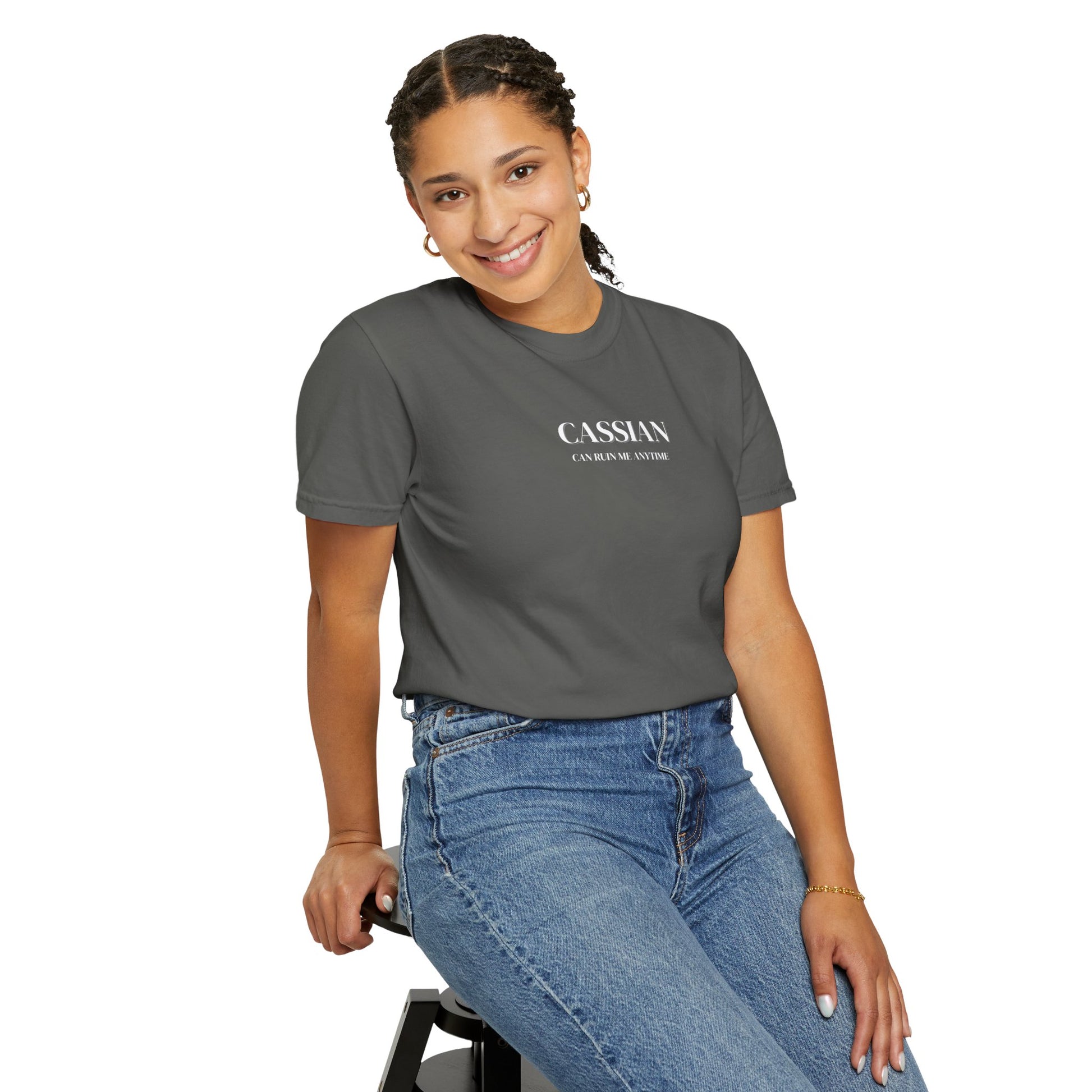 Woman wearing a gray t-shirt with 'CASSIAN' branding and blue jeans on a white background