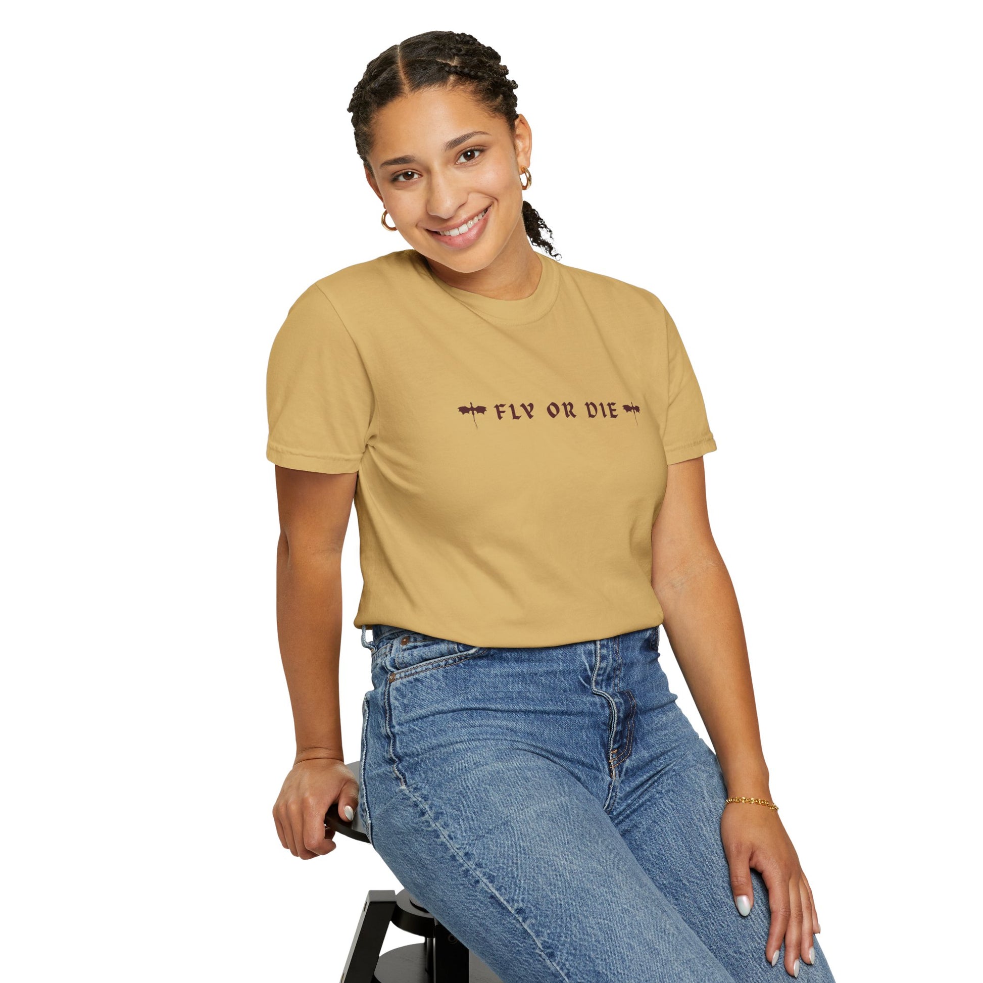Person wearing a beige t-shirt with 'FLY OR DIE' text and blue jeans on a white background