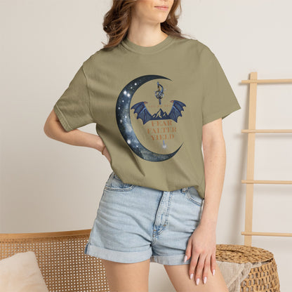 Person wearing a green t-shirt with a graphic design of a crescent moon and dragon, standing against a neutral background.