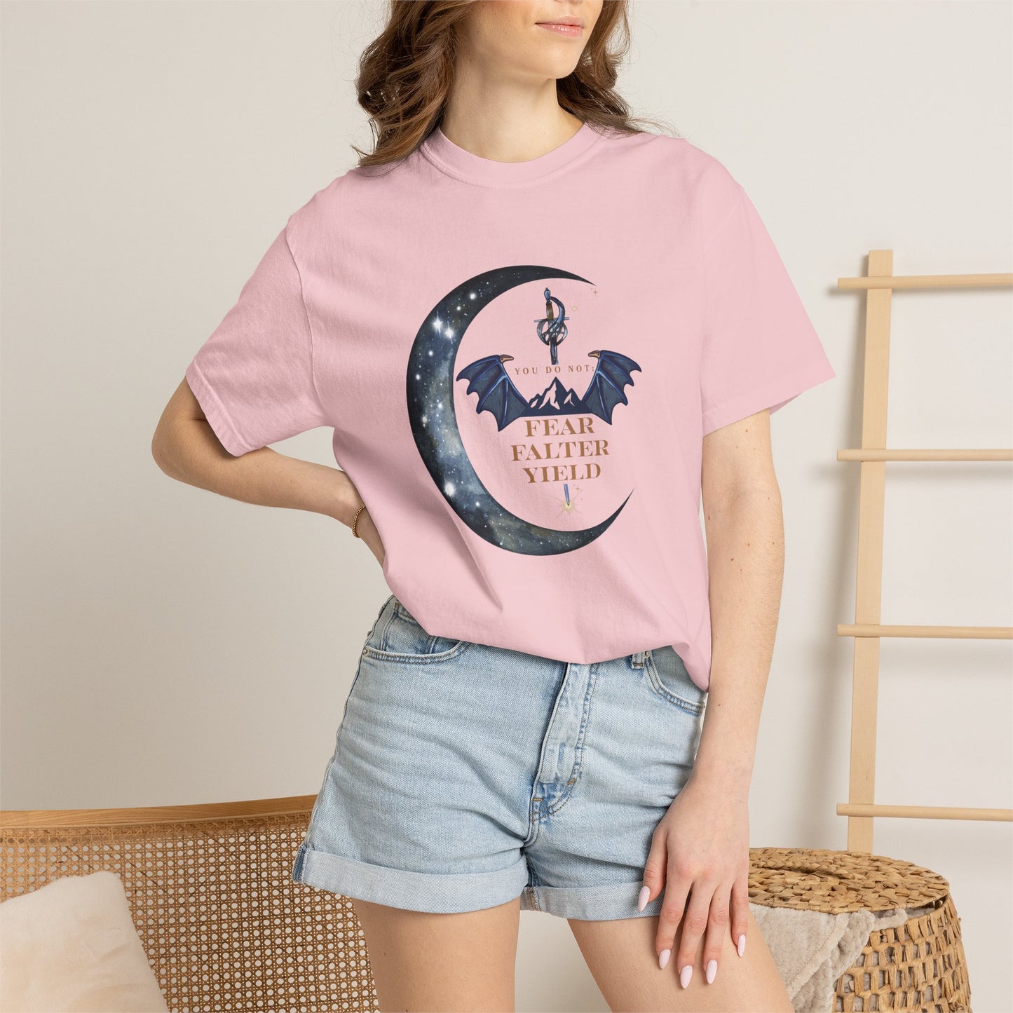 Person wearing a pink t-shirt with a graphic design and text, standing against a neutral background.